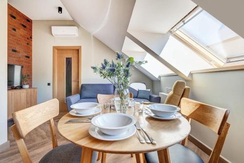 Un comedor con mesa y sillas de madera. en Domillion 1bdr New old town apt U2307, en Vilna