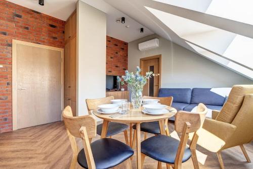 a dining room with a table and chairs and a blue couch at Domillion 1bdr New old town apt U2308 in Vilnius