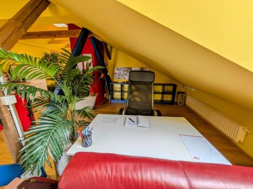 a room with a white table and a red couch at Anton's bunte Welt (100 m², Parkplatz, Garten und viel mehr) in Albersdorf