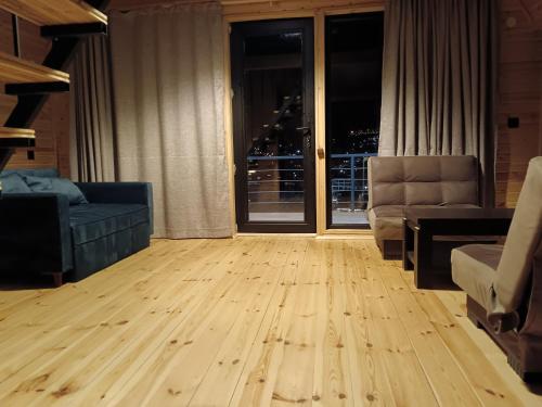 a living room with a wooden floor and a window at Belas guesthouse in Stepantsminda