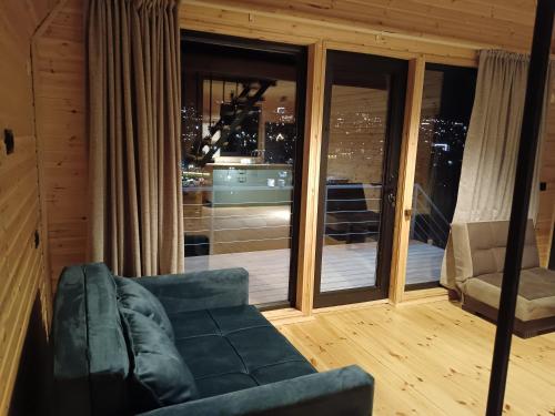 a living room with a couch and a large window at Belas guesthouse in Stepantsminda