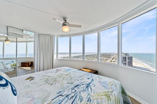 a bedroom with a bed with a view of the ocean at On the Beach-2/Br 2/Bath, 26th floor! Spectacular views of Ocean & River in Daytona Beach Shores