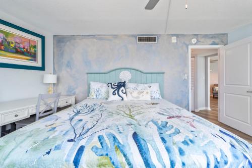 a bedroom with a large bed with a blue wall at On the Beach-2/Br 2/Bath, 26th floor! Spectacular views of Ocean & River in Daytona Beach Shores