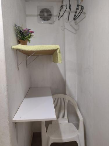 a white table and a chair in a room at Hospedaje Bonanza in Santa Fe de Antioquia