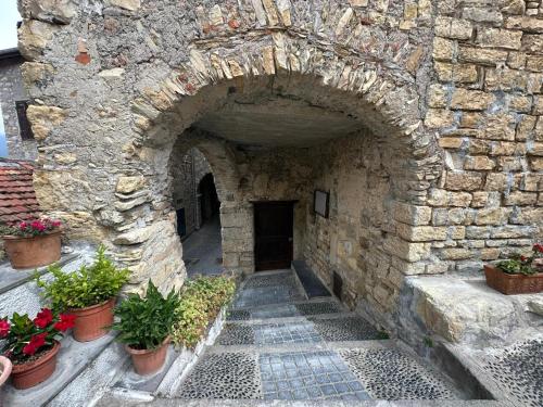 an archway in a stone building with potted plants at Piccolo Paradiso in Chiusanico