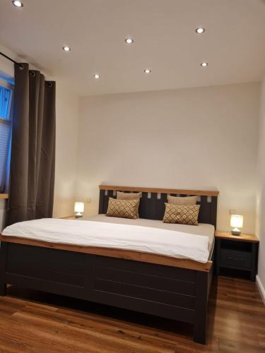 a large bed in a room with two lamps on tables at Ferienwohnung Ida 90 mq in Gernrode - Harz