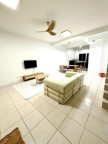 a living room with a couch and a ceiling fan at Rizku Homestay Port Dickson 4 Bedroom 4 Bathroom in Pasir Panjang