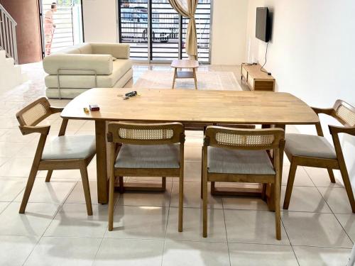 a wooden table and chairs in a living room at Rizku Homestay Port Dickson 4 Bedroom 4 Bathroom in Pasir Panjang
