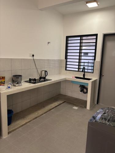 a kitchen with a counter and a sink and a window at Rizku Homestay Port Dickson 4 Bedroom 4 Bathroom in Pasir Panjang
