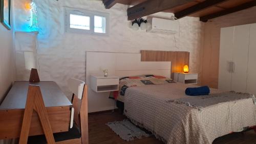 a bedroom with a bed and a table and a desk at Patagonia Faro Norte Lighthouse in Carmen de Patagones