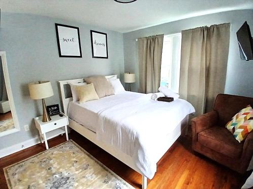 a bedroom with a large white bed and a chair at Soothing Private Room in Washington DC in Washington, D.C.
