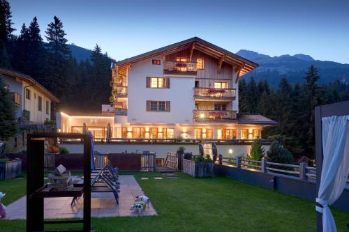 a large apartment building with lights on in a yard at Der Waldhof - Unique - A hidden gem in Sankt Anton am Arlberg