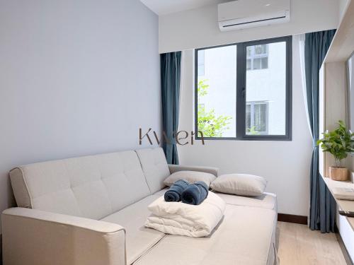 a white couch in a living room with a window at KWEN Vetro11 - Charm of KK City in Kota Kinabalu