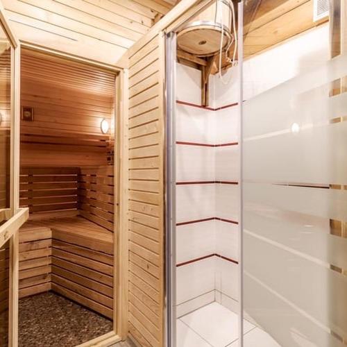 a sauna with wooden walls and a glass door at Casa de Greta in Svityazʼ