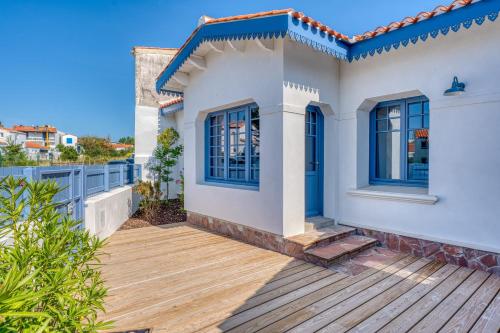 a house with a wooden deck in front of it at Villa Les Bains de Mer avec spa in Saint-Gilles-Croix-de-Vie