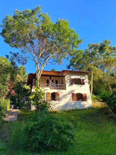 a house with a tree in front of it at Green House Chalé, hostel e pousada in Saquarema