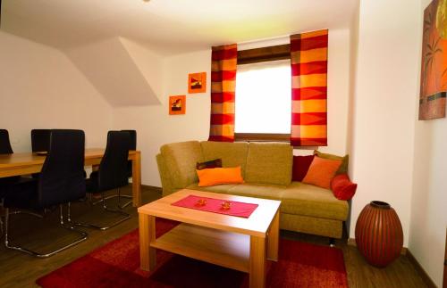 a living room with a couch and a table at Apart of me Ferienhaus Faaker See in Egg am Faaker See