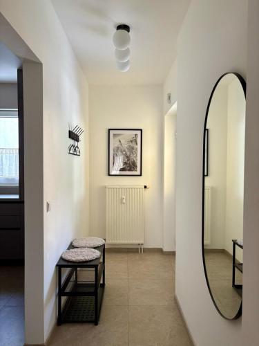 a hallway with a mirror and a stool at Fresh Apartment Upstairs & Free Parking in Graz