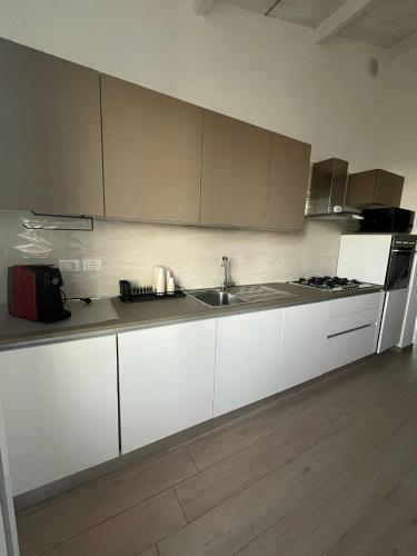 een keuken met witte kasten en een spoelbak bij Casa DeSte in Francavilla al Mare