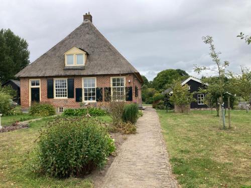 a brick house with a thatched roof at Romantische Bedstay de Volle Hand in Terwolde