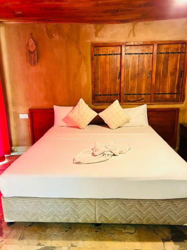 a bedroom with a large bed with white sheets at Yala Beddegama Eco in Kataragama