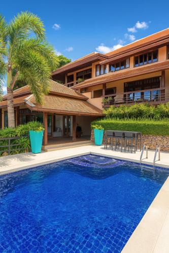 a swimming pool in front of a house at Blue Samui Ocean Villa - 3 Large Ensuite Bedrooms - Private Pool, Jacuzzi Villa & Car with driver - Near Four Seasons - Ocean & Mountains Views in Nathon Bay