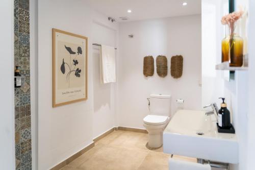 un bagno bianco con un water e un lavandino di Moorea Boutique - Only Adults a Chiclana de la Frontera