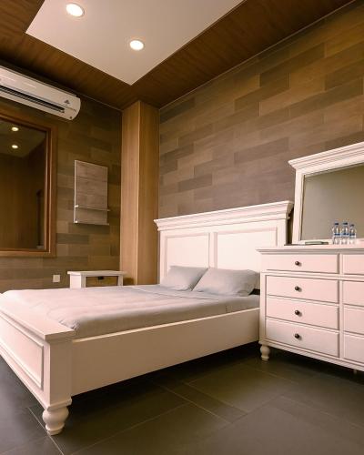 a bedroom with a white bed and a dresser at Lakeview Park Villas - Every Duplex with Private Pool in Ho Chi Minh City