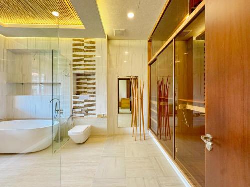 a bathroom with a tub and a toilet and a sink at Lakeview Park Villas - Every Duplex with Private Pool in Ho Chi Minh City