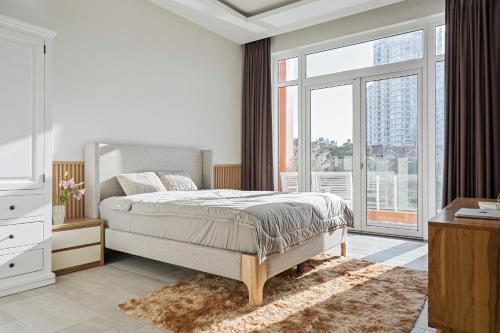 a bedroom with a bed and a large window at Lakeview Park Villas - Every Duplex with Private Pool in Ho Chi Minh City