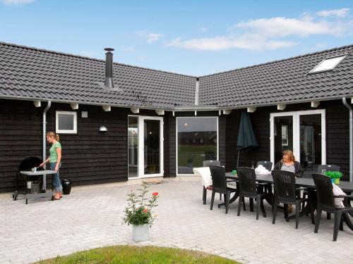 Nørre Lyngbyにある16 person holiday home in Løkken-By Traumの二人の女性がパティオのテーブルに座っている