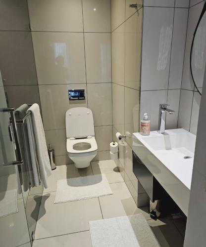 ein Badezimmer mit Toilette und Waschbecken in der Unterkunft ADM Luxury Apartment in Sandton in Johannesburg