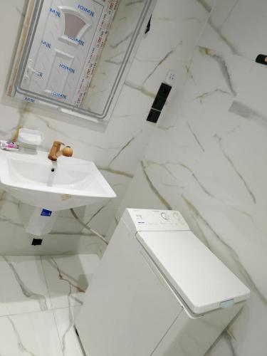 a white bathroom with a sink and a toilet at Adel Summer Annaba in Annaba