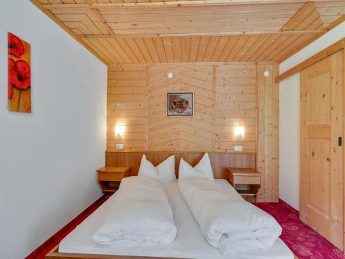 a bed with white pillows in a room at Apartment in Kappl near Ski Slopes in Kappl