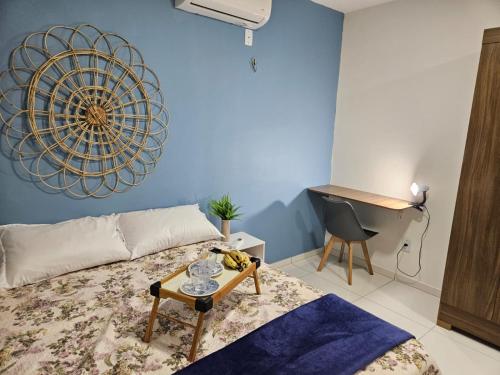 a room with a bed with a table and a desk at Casa aconchegante em Parnaíba in Parnaíba