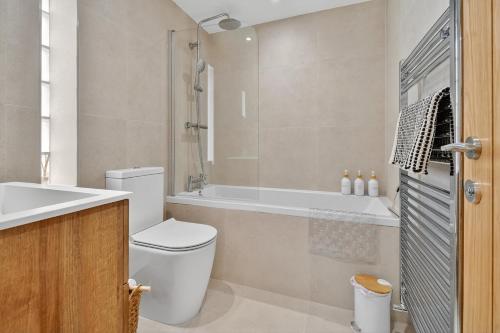 a bathroom with a toilet and a tub and a sink at 46 Tannery Mews in York