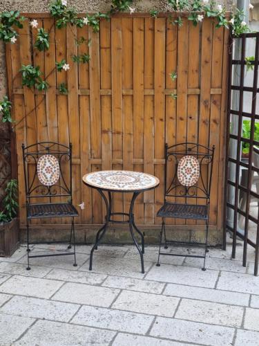a table and two chairs in front of a fence at Apartment Etta in Fažana