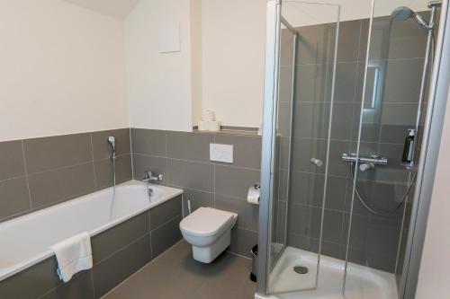 a bathroom with a shower and a toilet and a sink at Hotel Hafen Büsum in Büsum
