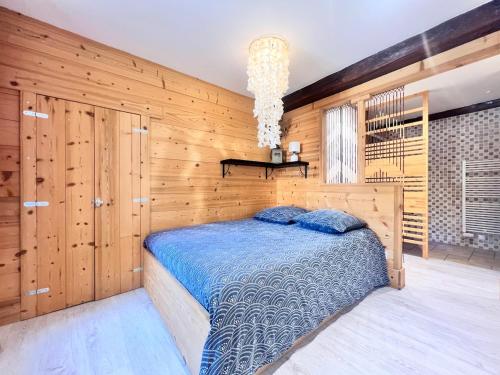 a bedroom with a bed and a wooden wall at Duplex au coeur d'Embrun in Embrun