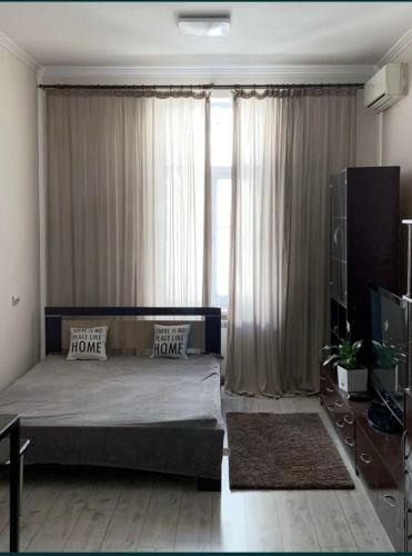 Un dormitorio con una cama y una ventana grande. en Olga's apartment, en Chernivtsi