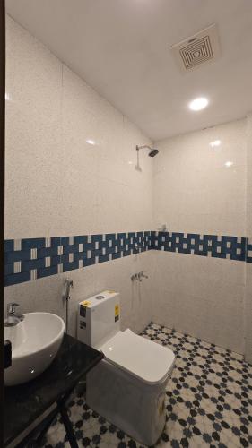 a bathroom with a white toilet and a sink at Hello rooms 29 in Haripād