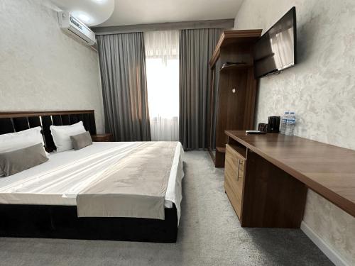 a hotel room with a bed and a desk at Grand Zamin Hotel in Tashkent