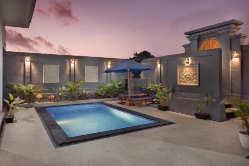 una casa con piscina y sombrilla en Rumah Wikan Bukit-Uluwatu, en Uluwatu