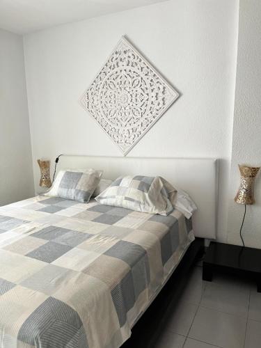 a bedroom with a bed with a checkered blanket at Apartamento Esquinzo Jandía in Playa Jandia