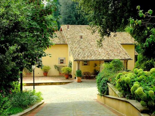a large yellow house with a patio in front of it at Apartment in Perugia with Pool & Terrace in Perugia