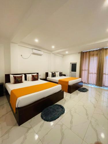 two beds in a room with two rugs at Ever Breeze Ella Hotel in Ella