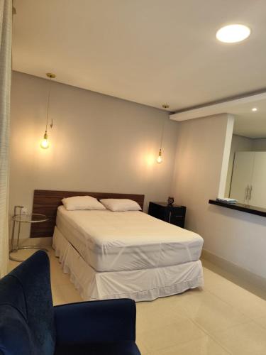 a bedroom with a large bed and a chair at Kitnet in Belém