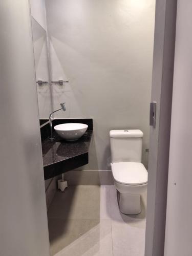 a bathroom with a white toilet and a sink at Kitnet in Belém