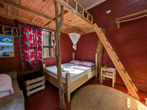 a bedroom with a bunk bed in a red brick wall at Meleji Studio House in Arusha