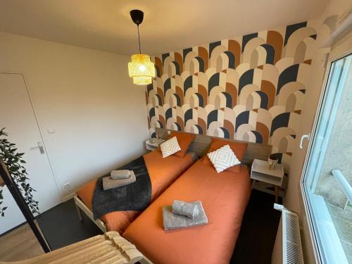 an orange couch with pillows on it in a room at La pétillante in Vertus